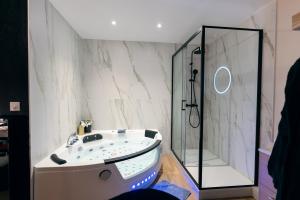 une salle de bain avec baignoire et douche dans l'établissement Love room - Le secret du marquis, à Provins