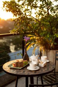 a table with a plate of food and cups and sandwiches at Lake Avenue Hotel Kandy in Kandy