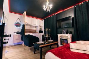 une chambre avec un lit et une table et une cuisine dans l'établissement Love room - Le secret du marquis, à Provins