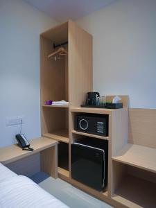 a room with a bed and a kitchen with a microwave at K Hotels by SYN in Bangalore