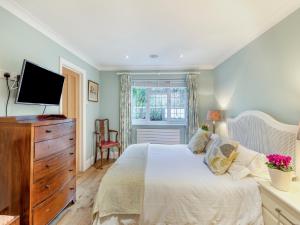 ein Schlafzimmer mit einem Bett mit einer Kommode und einem TV in der Unterkunft Longways in Penn + 12 Fotos