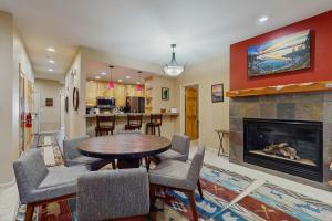 een woonkamer met een tafel en een open haard bij Tavern Inn #38 in Olympic Valley