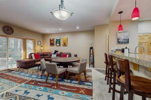 een woonkamer met een bank, een tafel en stoelen bij Tavern Inn #38 in Olympic Valley