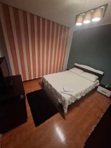 una camera da letto con un letto e una parete a strisce di CasaLuxi a Alexandria