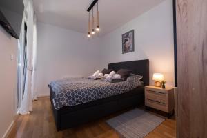 a bedroom with a bed and a night stand with a lamp at Apartman Manči in Zaprešić