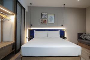 une chambre avec un grand lit blanc et un canapé dans l'établissement Hilton Garden Inn Ankara Cankaya, à Ankara