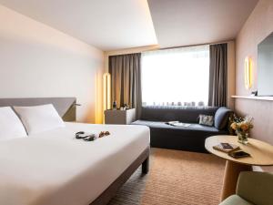 Un pat sau paturi într-o cameră la Novotel Nancy