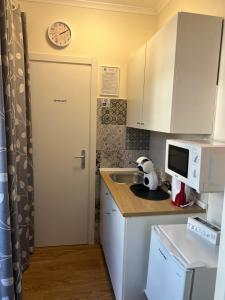 a small kitchen with a sink and a clock on the wall at Porto Segreto in Fiumicino