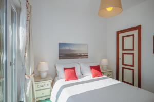 a bedroom with a white bed with red pillows at POSEA Collection - Villa La Nice in Positano