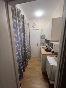 a small kitchen with curtains and a sink and a counter at Porto Segreto in Fiumicino