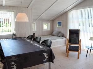 a bedroom with a bed and a table and chairs at 6 person holiday home in Løkken in Løkken