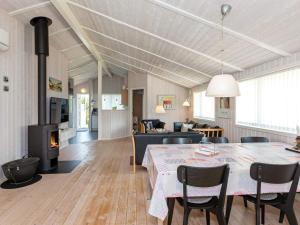 a living room with a table and a fireplace at 6 person holiday home in Løkken in Løkken