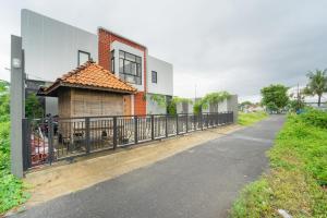 a building with a fence next to a street at Kragilan CoLiving By ARBA in Jetis