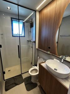 a bathroom with a shower and a toilet and a sink at RCM Vilas - Studio H Sunrise in Boa Vista