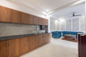 a kitchen with wooden cabinets and a blue couch at Maverick Hills Kasauli in Kasauli