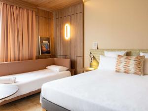 a hotel room with a bed and a couch at Novotel Toulouse Purpan Aéroport in Toulouse +106 photos
