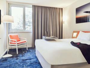 una habitación de hotel con una cama y una silla en ibis Styles Marseille Aéroport, en Vitrolles