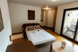 ein Wohnzimmer mit einem Bett und einer Couch in der Unterkunft Courbevoie Studio terrasse situe pres de Paris in La Garenne-Colombes