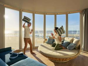 a man and woman standing in a room with a large bed at Novotel Thalassa Le Touquet in Le Touquet-Paris-Plage