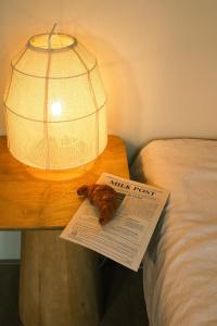 a table with a lamp and a book on a bed at Milk and cookies in Venlo