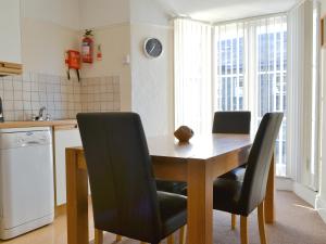 a kitchen with a wooden table and black chairs at Cat Bells in Keswick