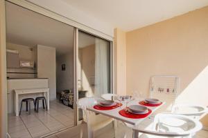 ein Esszimmer mit einem weißen Tisch und Stühlen in der Unterkunft Chez Juan - T3 Climatisé - Piscine et parking in Sète