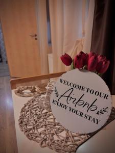 a cake with red roses on a table with a sign at Ultracentral Apartment 2 in Braşov