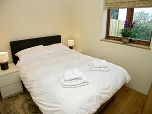 Stoneにあるソーンズデイル オストハウスの白いベッドとタオルが2枚置かれた寝室