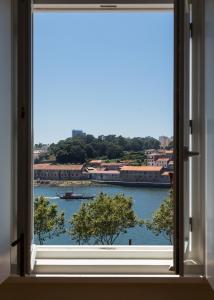 ein Fenster mit Blick auf einen Wasserkörper in der Unterkunft Seventyset Flats - Porto Historical Center in Porto