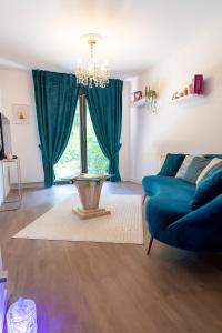 Una sala de estar con un sofá azul y una mesa. en L Ecrin Appartement 40m2 Évreux Deco Raffinée Fibre Haut Debit Parking, en Évreux 1 foto más