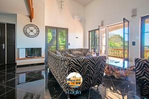 a living room with a zebra print couch and a clock at Villa Layla - 5 étoiles - 10 personnes - Vue mer in Sète