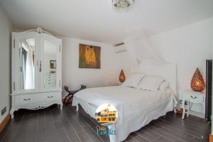 a bedroom with a white bed and a mirror at Villa Layla - 5 étoiles - 10 personnes - Vue mer in Sète +23 photos