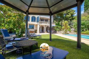 a patio with a table and chairs and a house at Villa Layla - 5 étoiles - 10 personnes - Vue mer in Sète