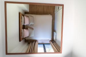 Un espejo en una habitación con una cama y una ventana. en L Ecrin Appartement 40m2 Évreux Deco Raffinée Fibre Haut Debit Parking, en Évreux