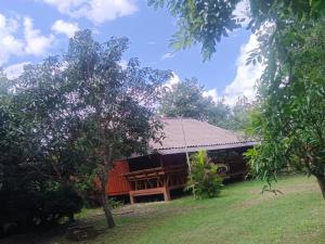 a building in the middle of a field with trees at Doisaket hills in Doi Saket