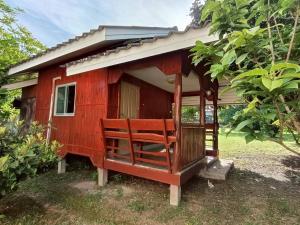 a red house with a porch and a bench in front at Doisaket hills in Doi Saket