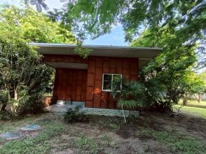 a small red house with a porch and trees at Doisaket hills in Doi Saket +6 photos