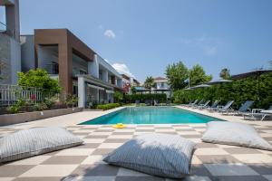 a swimming pool with two pillows on a patio at EllinFos Apartments in Hanioti