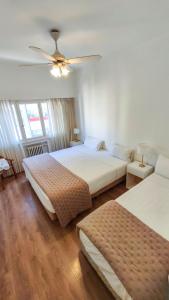 a bedroom with two beds and a ceiling fan at Argentino Hotel in Mar del Plata +60 photos