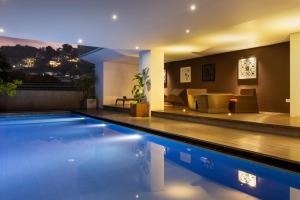 a house with a swimming pool and a living room at Lake Avenue Hotel Kandy in Kandy
