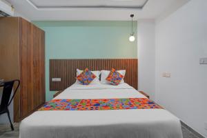 een slaapkamer met een groot bed met kleurrijke kussens bij FabHotel Morning Glory in Bangalore +17 foto's