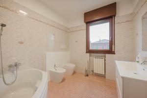 a bathroom with a tub and a toilet and a sink at 2 camere, parcheggio gratis, 10 minuti da Venezia in Venice +17 photos
