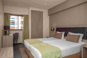 a hotel room with a large bed and a window at VIP Inn Berna Hotel in Lisbon +35 photos