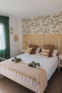 1 dormitorio con 1 cama blanca grande y papel pintado con motivos florales en Bella Palace, Apartamento acogedor junto al mar, en Alcanar