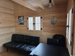 a living room with a leather couch and a table at #3 La Maison du Dragon in Saint-Onésime