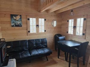 a living room with a leather couch and a table at #3 La Maison du Dragon in Saint-Onésime +15 photos