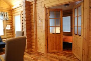 un chalet en rondins avec une pièce équipée d'un bureau et de chaises dans l'établissement Luosto Villa D, à Luosto