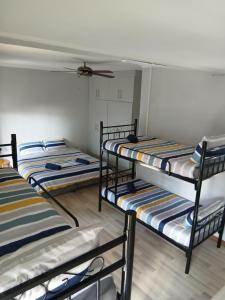 three bunk beds in a room with a ceiling at Bedrock inn in Harrismith +1 photo