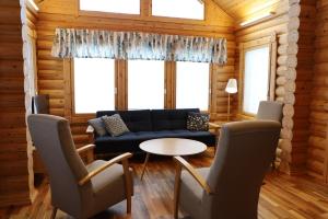 un salon avec un canapé, une table et des chaises dans l'établissement Luosto Villa D, à Luosto