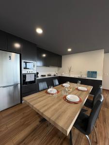 eine Küche mit einem großen Holztisch und Stühlen in der Unterkunft Sunset Valley House in Ribeira Brava